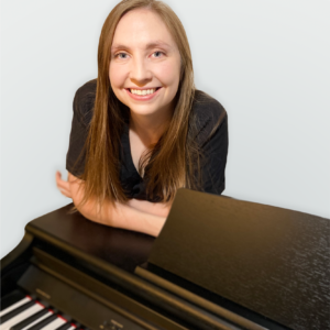Becky Spiewak leaning on a piano